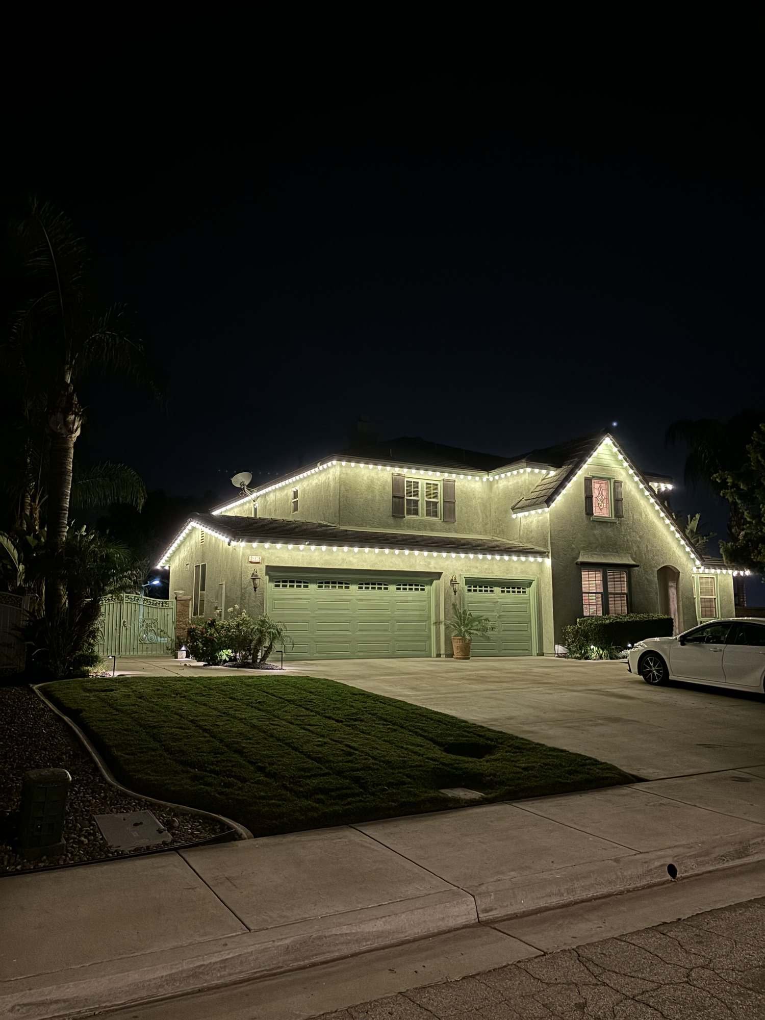 Two-story home with warm white C9 lights outlining every roofline and gable